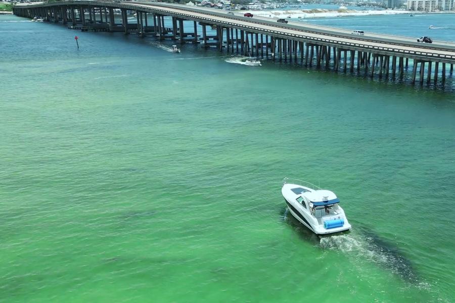 The Infinity Getaway Charters yacht cruising the East Pass beside the Destin bridge