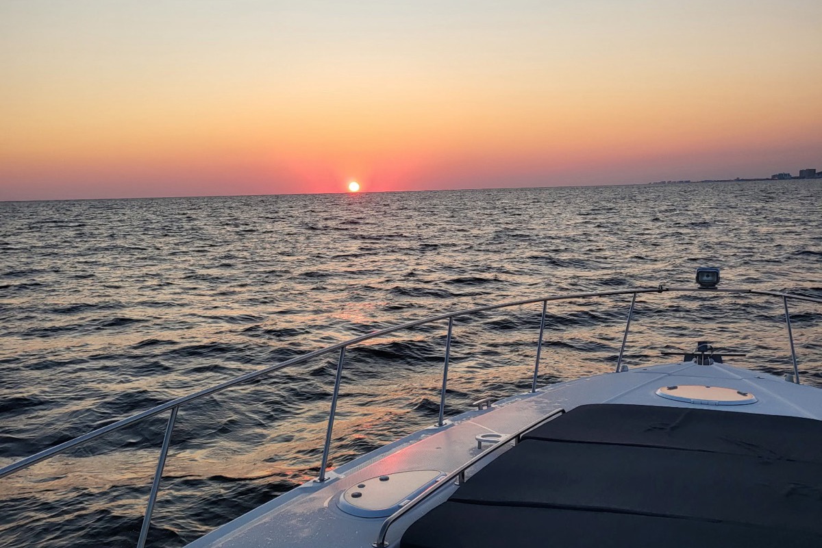 Sunset over the water from the bow sunpad of the Infinity Getaway Charters yacht
